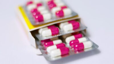 white and red medication pill on yellow box