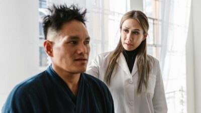 A medical practitioner attentively consulting a patient in a bright indoor clinic setting.