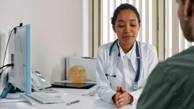 A female doctor consulting a patient in a modern medical office setting.