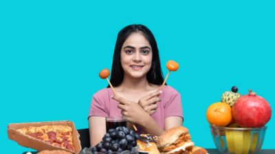 a woman holding a spoon in her mouth with food in front of her