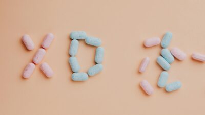 Top view composition of yummy pink and blue candy dots placed on pink background