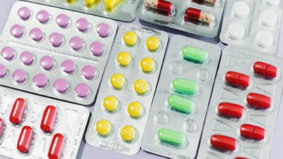 A variety of colorful pills and tablets in blister packs, representing diverse medication types.