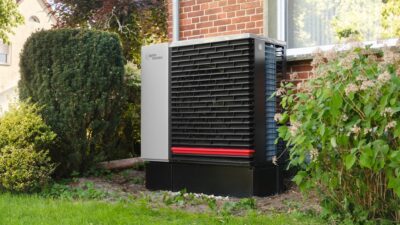 Outdoor heat pump unit next to a brick building.