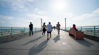 People jogging on a pier with ocean background
