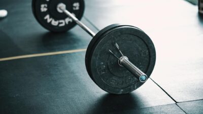 A detailed image of a barbell resting on a gym floor, perfect for fitness themes.