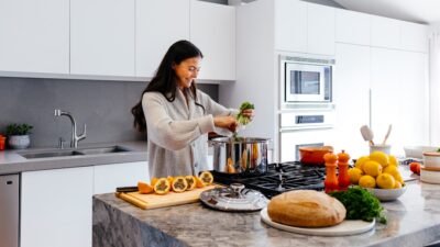 woman smiling while cooking