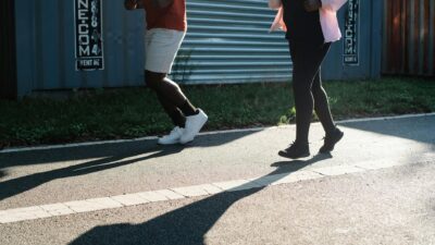 Two people jogging outdoors on a sunny day, emphasizing fitness and healthy lifestyle.