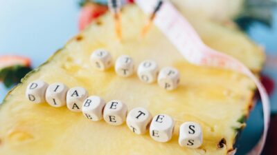Symbolic image of diabetes prevention message with pineapple and insulin syringes.
