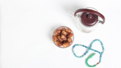a cup of nuts next to a string of beads