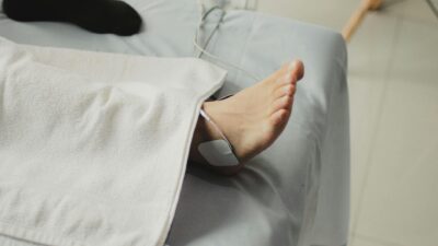 A close-up image of a bare foot with a medical electrode, suggesting a healthcare setting.