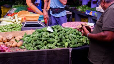 A man shops for fresh produce at an outdoor market.