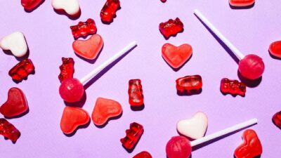 Colorful lollipops and gummy candies on a lilac background. Perfect for sweet treats theme.