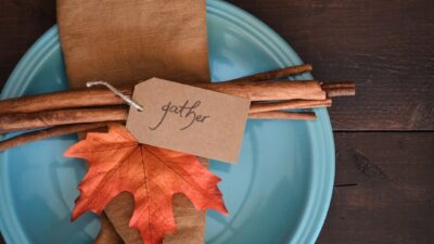 a blue plate topped with an orange and brown leaf
