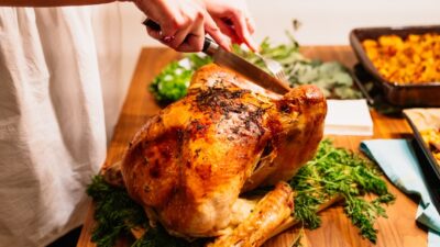 person about to slice the roasted chicken