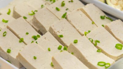 Close-up of tofu slices garnished with green onions, ideal for vegan meals.