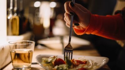 a person holding a fork over a plate of food