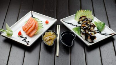 Elegant display of Japanese sushi and sashimi on a dark wood table.