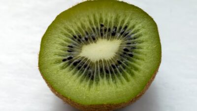 a kiwi cut in half on a white surface