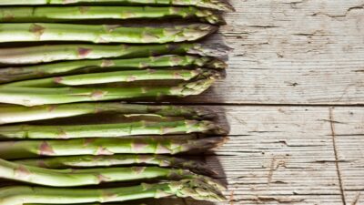 A bunch of asparagus sitting on top of a wooden table