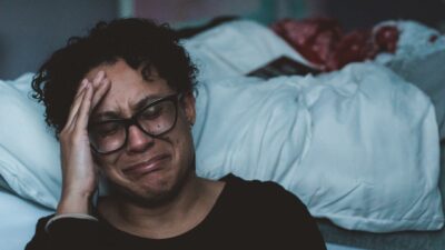person crying beside bed