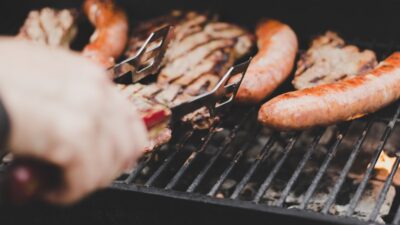 person grilling sausage and meat