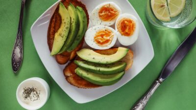 a white plate topped with eggs and avocado