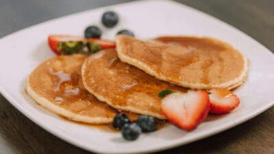Mouth-watering pancakes topped with syrup and fresh berries, perfect for a wholesome breakfast.