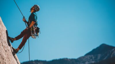 man in blue and orange jacket and black helmet riding on black and white ski lift