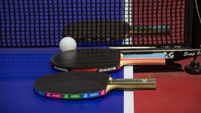 two ping pong paddles resting on a ping pong table