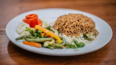 Delicious vegetarian rice dish with mixed vegetables on a white plate, perfect for healthy meals.