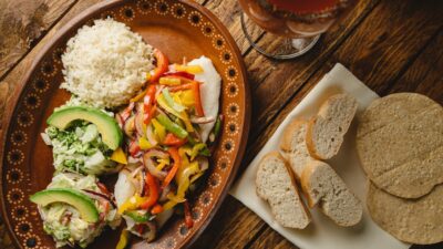 a plate of food on a table next to a glass of beer