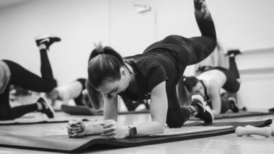 A group of people in a gym doing push ups