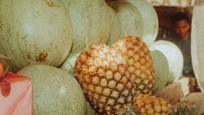 Close-up of watermelons and pineapples at a market stall in Zaria, Nigeria.