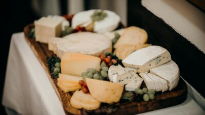 A delicious assortment of gourmet cheeses and grapes on a wooden platter.